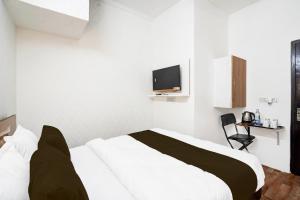 a bedroom with a bed and a tv on the wall at Hotel O Kiiza Stay House in New Delhi