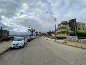 a street with cars parked on the side of the road at "Marenostro" Dpto #3, departamento frente al mar in Algarrobo +13 photos