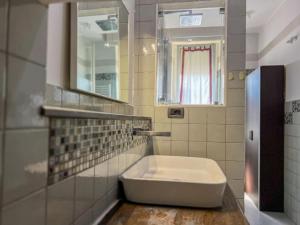 a bathroom with a tub and a mirror and a sink at A due passi dal mare - free Parking in Genova +34 photos