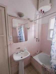 a bathroom with a sink and a tub and a mirror at Departamento compartido de artistas para viajeros en el corazón de Mendoza in Mendoza