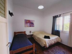 a bedroom with two beds and a window at Departamento compartido de artistas para viajeros en el corazón de Mendoza in Mendoza +6 photos