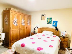 a bedroom with a bed and a wooden cabinet at Maison L aurore in Lobios