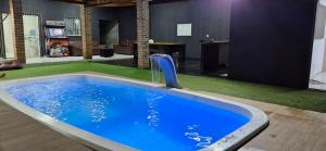 a large blue pool with a water fountain in a room at Casa com piscina em Itamaracá in Itamaracá