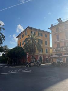 a building with a palm tree in front of a street at La casa di Eli in Genoa