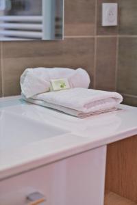 Un par de toallas sobre el mostrador del baño. en Le Joyau, en Reims