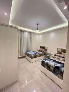two beds in a room with white walls at COMFY ZONe in Sharm El Sheikh