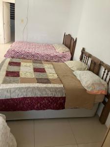 San AntonioにあるCasa de Huéspedes Encanto Raramuriのキルト付きの客室で、ツインベッド2台が備わります。 +6枚の写真