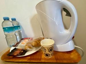 a tea pot and a cup on a table with water bottles at Great and cozy Room in the center of Puerto del Rosario B&B in Puerto del Rosario
