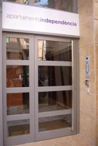 a glass door in a building with a sign on it at Apartaments Independencia in Barcelona