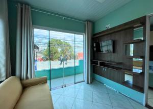 a living room with a couch and a large window at Ramos Residence - AP101 in Navegantes +10 photos