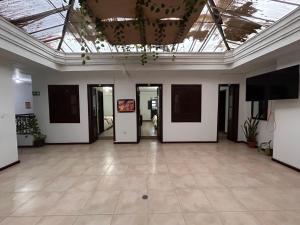 a large room with white walls and a ceiling with windows at Hotel Santa Marta Centro Histórico in Popayan