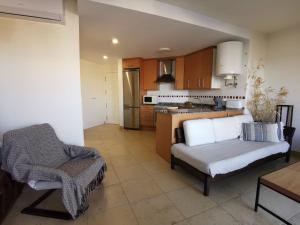 un salon avec un canapé et une cuisine dans l'établissement ESTUDIO en PRIMERA LINEA PLAYA, à San Juan de Alicante