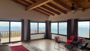 a living room with views of mountains from windows at Cabaña Real del Alto in Puerto Vallarta