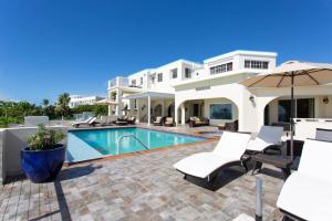 a villa with a swimming pool and patio furniture at Villa Anguillitta in Blowing Point Village