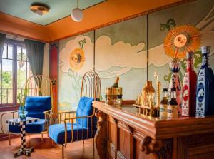 a room with two chairs and a bar with a painting on the wall at The Nirvana Apartment Hotel in Los Angeles