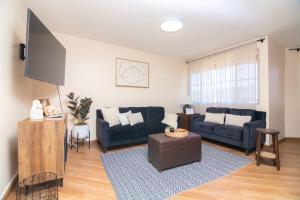 a living room with two blue couches and a flat screen tv at Life Hospitality TJ in Tijuana