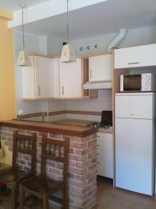 a kitchen with white cabinets and a white refrigerator at El Bosque Rural House in El Bosque