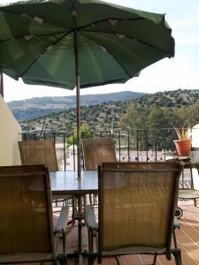 a table and chairs with an umbrella on a patio at El Bosque Rural House in El Bosque