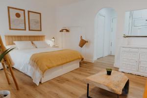 ein weißes Schlafzimmer mit einem Bett und einem Tisch in der Unterkunft Apartamento Hermi in Torrox