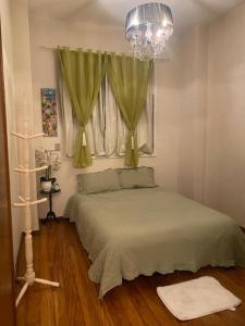 1 dormitorio con 1 cama con lámpara de araña y ventana en Flamengo Vibes Stay & Shine in Rio, en Río de Janeiro