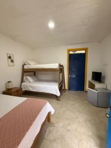 1 Schlafzimmer mit 2 Etagenbetten und einer blauen Tür in der Unterkunft FINCA HOTEL Encanto Quindio in La Tebaida
