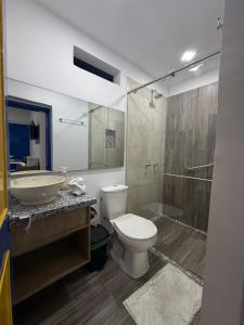 ein Badezimmer mit Toilette, Waschbecken und Dusche in der Unterkunft FINCA HOTEL Encanto Quindio in La Tebaida