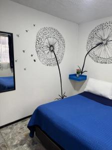 a bedroom with a blue bed and two umbrellas on the wall at Casa Cristal in Mexico City