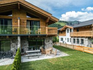 una casa con un patio con mesa y sillas en Chalet Schneelöwe S, en Leogang