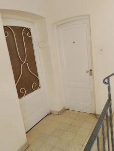 a white room with a door and a tiled floor at Departamento compartido de artistas para viajeros en el corazón de Mendoza in Mendoza
