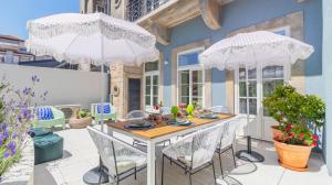 a patio with a table and two umbrellas at Carmo Apartamentos in Porto
