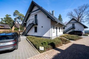 a white house with a car parked in front of it at Strandhaus-4-EG in Marienfelde +16 photos
