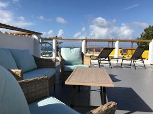 a patio with couches and a table and chairs at Mi Barca Su Casa in Isabela