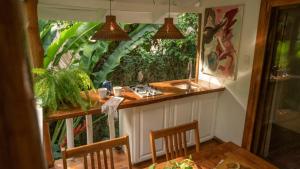 a kitchen with a counter and a table and chairs at Surf Casitas - Mid Tide Bungalow in Santa Teresa Beach +19 photos