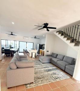 a living room with a couch and a staircase at Casa Ola Mita in Punta Mita