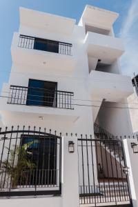 a white house with black fence at Casa Ola Mita in Punta Mita