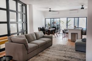a living room with a couch and a dining room at Casa Ola Mita in Punta Mita
