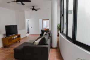 a living room with a couch and a tv at Casa Ola Mita in Punta Mita