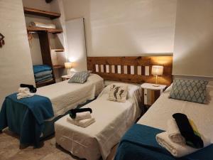 a hotel room with three beds and two tables at UMA Cabañas in Lozano