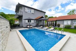 a swimming pool in front of a house at Holiday house with a swimming pool Lucane, Zagora - 23648 in Sinj