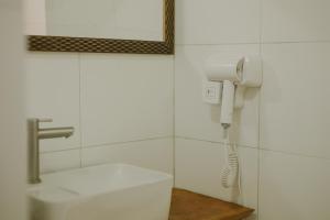 a bathroom with a toilet and a phone on the wall at Casa cacau - Casinhas da Serena in Caraíva