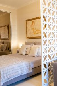 a bedroom with a bed and a painting on the wall at Estúdio AMar - Always Algarve in Porches +22 photos