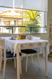 a white table with chairs and a white table cloth at Estúdio AMar - Always Algarve in Porches