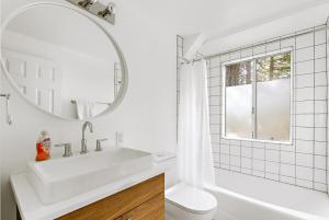 a white bathroom with a sink and a mirror at Luxury A-Frame Retreat in Lake Arrowhead +44 photos