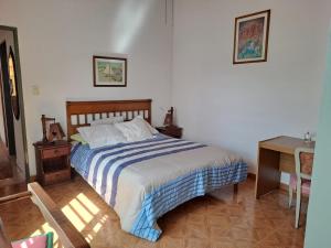 a bedroom with a bed and a table and a desk at Lo de Mary in Villa Elisa