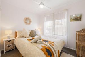 a bedroom with a large bed and a window at Good Vibes at Surf Beach with Spa in Surf Beach