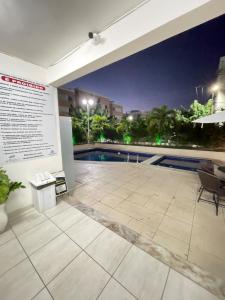a exhibit in a building with a pool at night at AP De Alto Padrão - Climatizado, Piscina e Academia No SIM in Feira de Santana