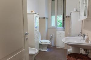 a white bathroom with a toilet and a sink at LN ETNA HOUSE-villa ad uso esclusivo in Pedara +67 photos