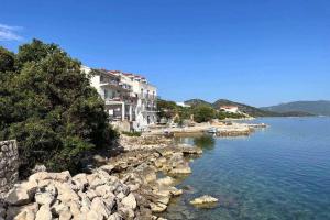 a building on the shore of a body of water at Apartments by the sea Cove Pjestata, Peljesac - 24021 in Janjina