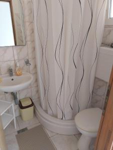 a bathroom with a shower curtain with a toilet and a sink at Apartments by the sea Cove Pjestata, Peljesac - 24021 in Janjina +19 photos