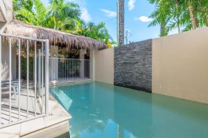 a swimming pool with a gate and some palm trees at Port Douglas Sea Breeze Villa 2 in Port Douglas